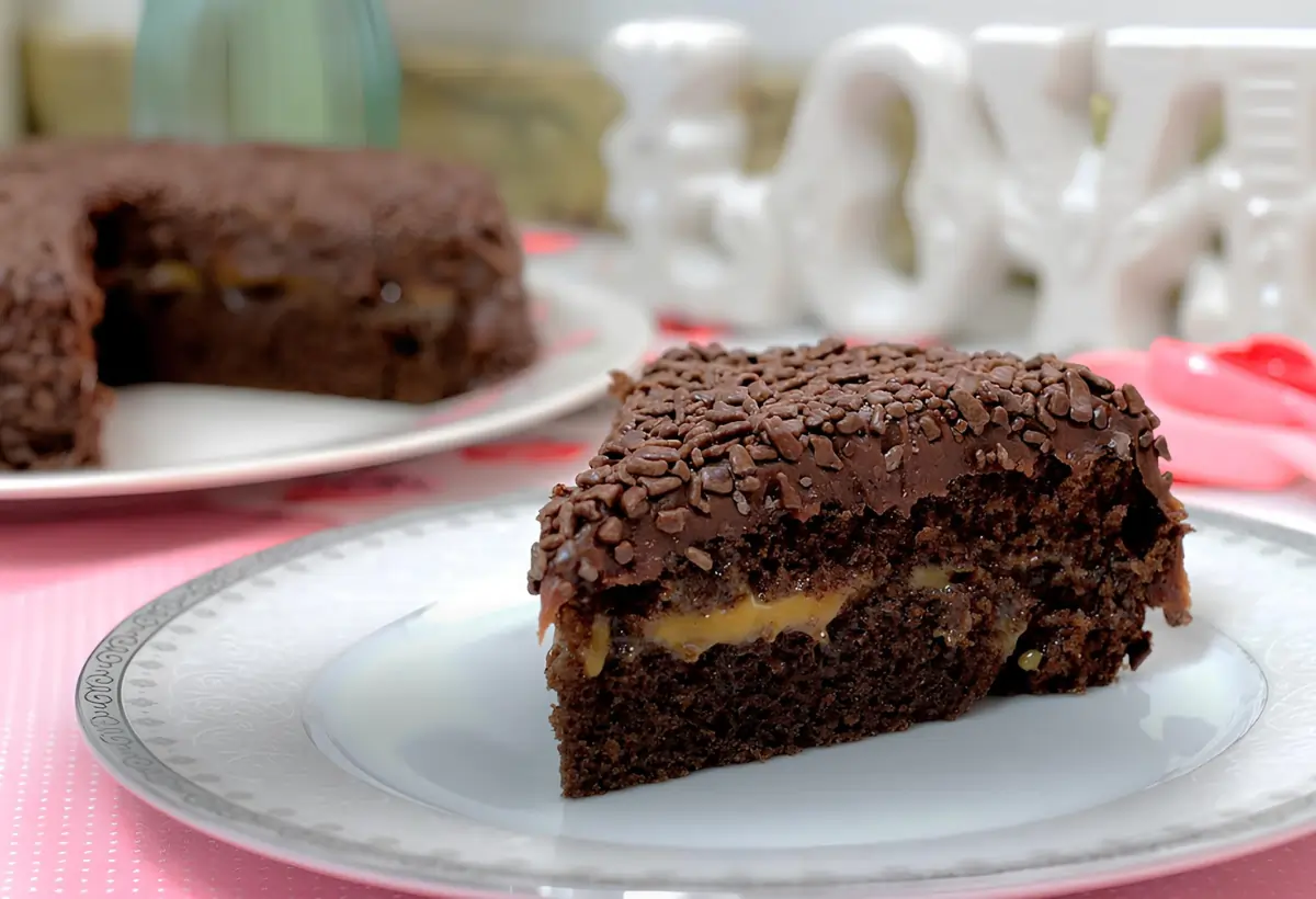 um prato com uma fatia de bolo nega maluca recheada com doce de leite.