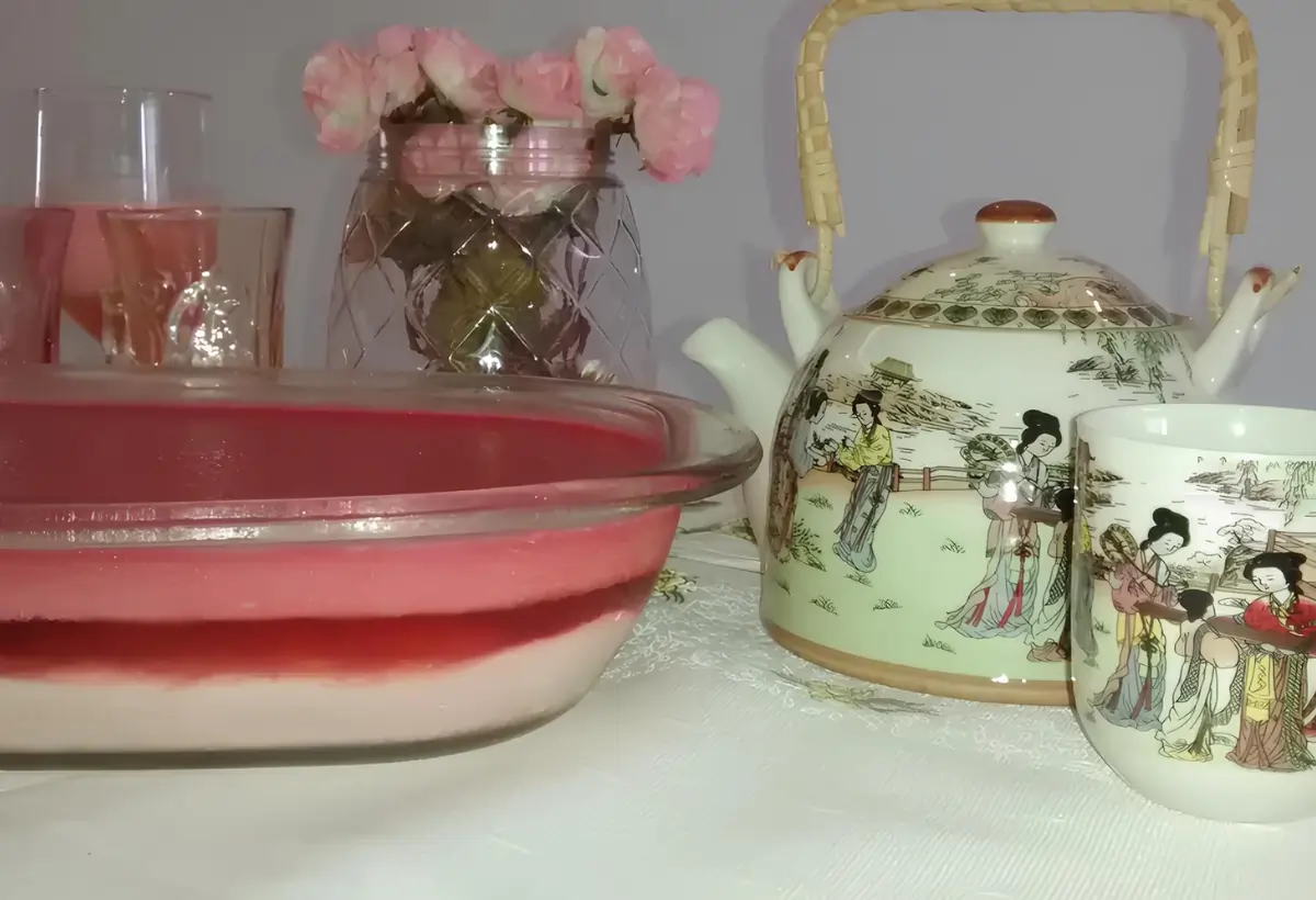 Uma mesa decorada com uma travessa de pudim chinês e outros objetos decorativos.