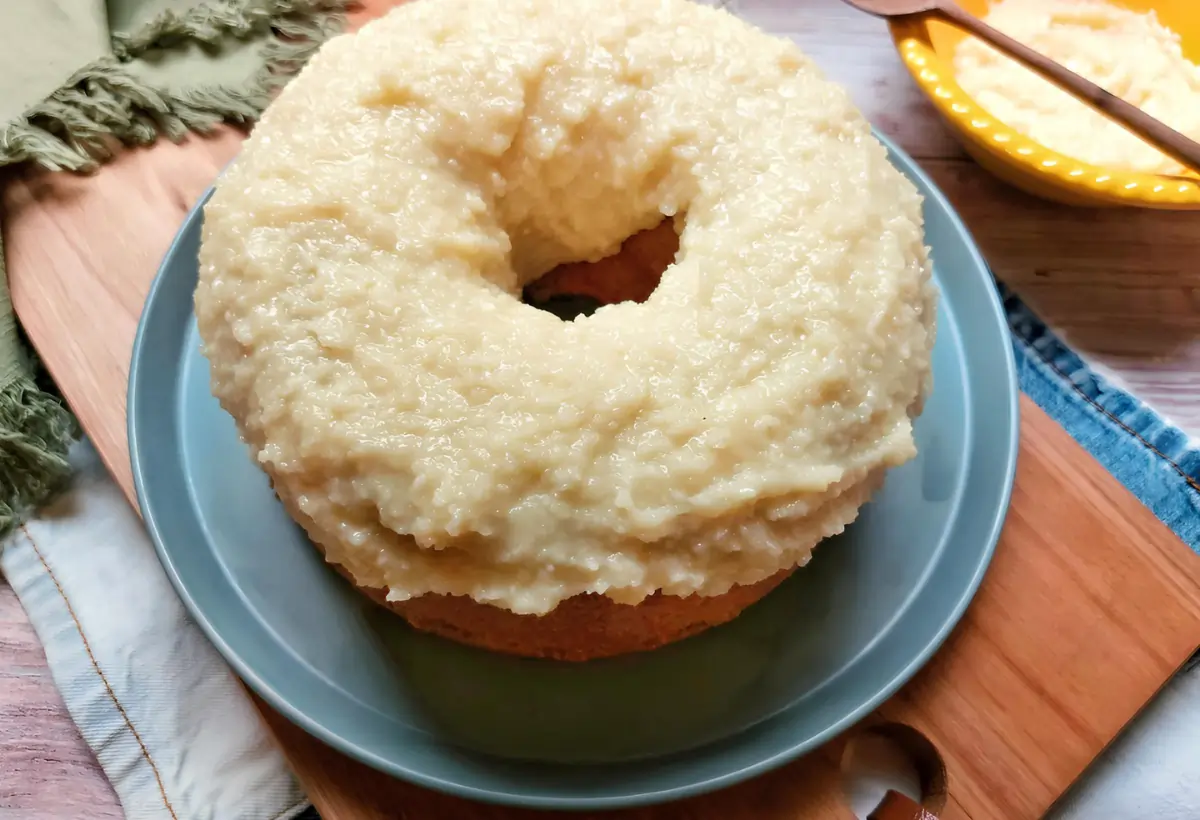 Um prato com um bolo de fubá com cobertura de bejinho.