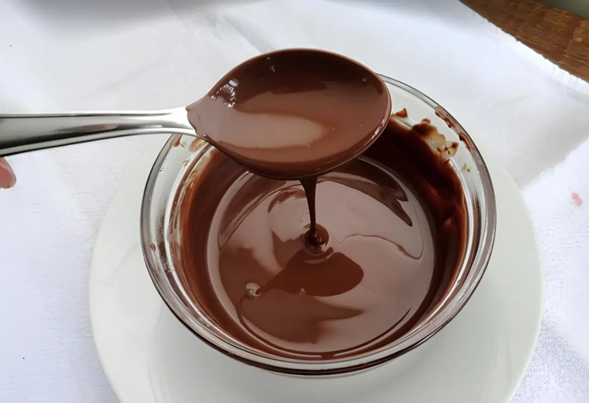 uma travessa redonda pequena de vidro com uma calda de chocolate para bolo de caneca.
